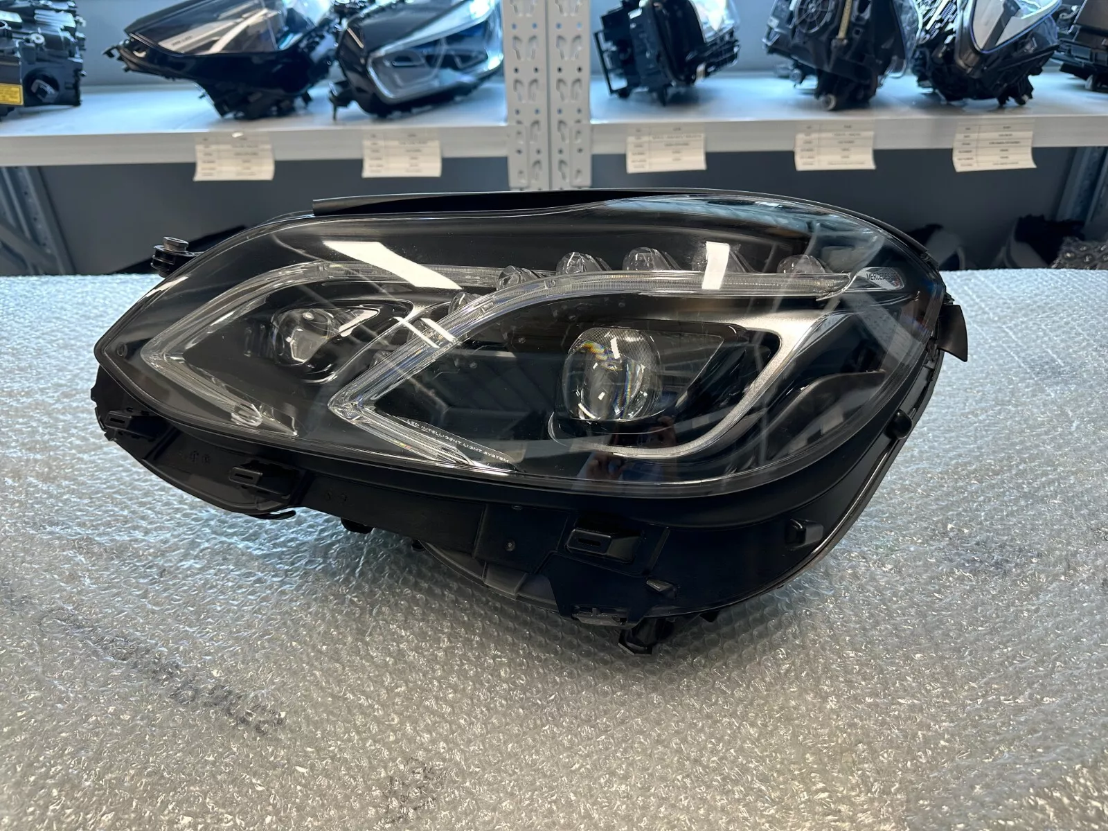 Used genuine Mercedes-Benz E-Class W212 FL LED Intelligent left side headlight (part number A2128202339) showcasing its sleek design and advanced lighting technology.